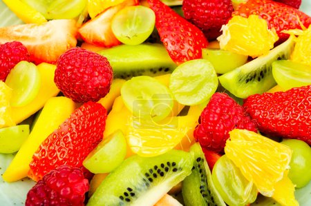 Téléchargez les photos : Vitamin salad of mango, citrus, banana and berries. Close up, food background - en image libre de droit