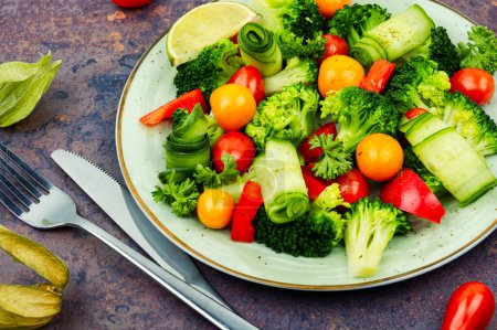 Foto de Green vegan salad with broccoli, tomato, cucumber and physalis. - Imagen libre de derechos