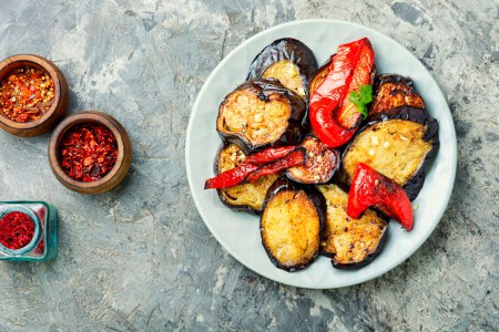 Téléchargez les photos : Roasted eggplant and grilled bell pepper on stone or concrete background, top view - en image libre de droit
