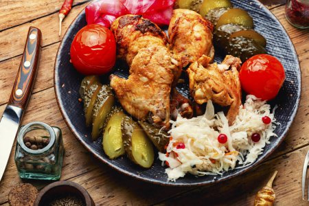 Téléchargez les photos : Prepared chicken pieces with pickles vegetables in a plate on the table - en image libre de droit