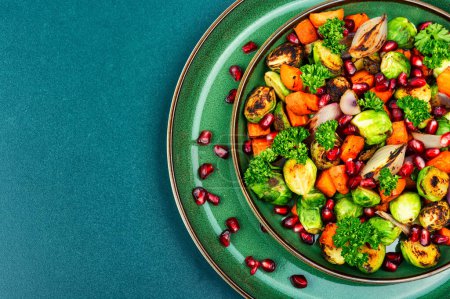 Foto de Salad with Brussels sprouts, carrots, herbs and pomegranate. Top view with copy space. Vegan menu - Imagen libre de derechos