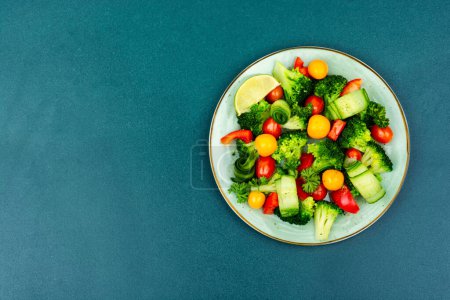 Téléchargez les photos : Green vegan salad with broccoli, tomato, cucumber and physalis. Space for text, flat lay - en image libre de droit