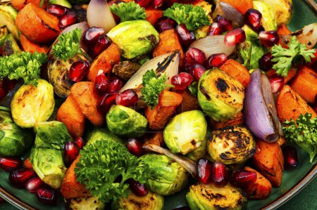 Foto de Salad with Brussels sprouts, carrots, decorated with greens and pomegranate seeds. Food background - Imagen libre de derechos