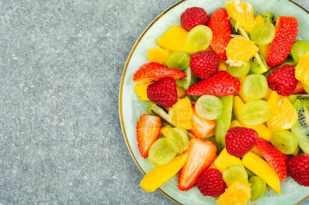 Téléchargez les photos : Delicious fresh salad of mango, citrus, banana and berries. Space for text - en image libre de droit