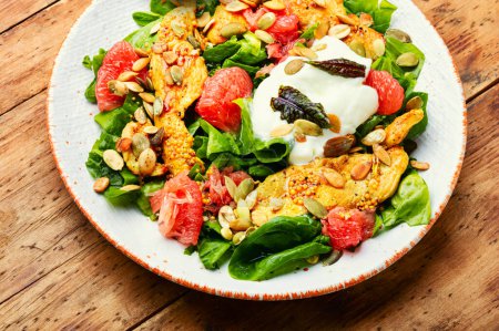 Photo for Meat salad with chicken meat, greens and citrus fruits on the plate - Royalty Free Image