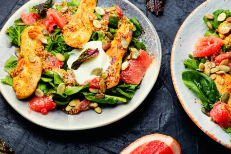 Foto de Meat salad with chicken breast, lettuce and citrus fruits. Healthy and detox food concept - Imagen libre de derechos
