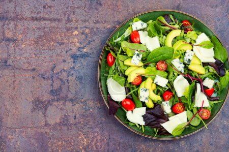 Foto de Salad with fresh lettuce, greens, avocado, tomatoes and cheeses. Space for text. - Imagen libre de derechos