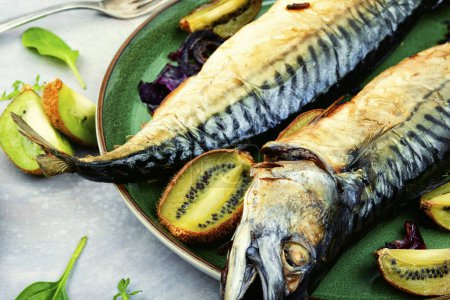 Téléchargez les photos : Whole tasty mackerel fish grilled with kiwi fruits. - en image libre de droit