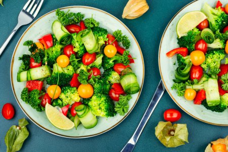 Foto de Ensalada de vitaminas con brócoli, tomate, pepino y physalis. Alimento saludable - Imagen libre de derechos