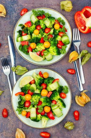 Téléchargez les photos : Salade avec brocoli, poivron, tomate, concombre et physalis. Vue du dessus - en image libre de droit