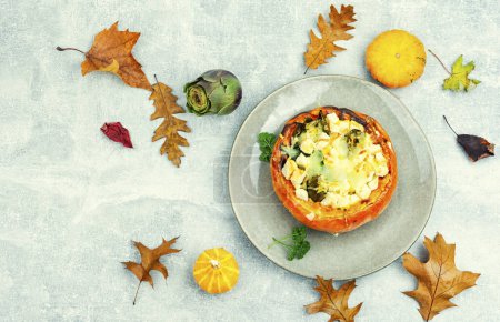 Foto de Cooked baked pumpkin with broccoli, artichoke and cheese. Autumnal food, space for text - Imagen libre de derechos