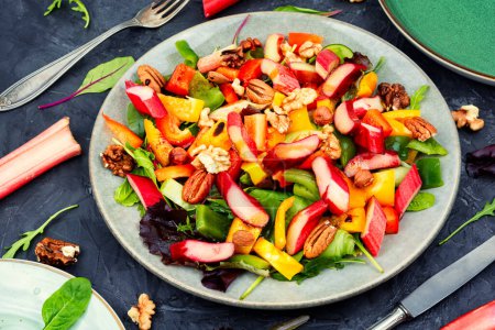 Foto de Fresh diet salad of rhubarb, bell pepper, leaf salad and nuts. Ketogenic - Imagen libre de derechos
