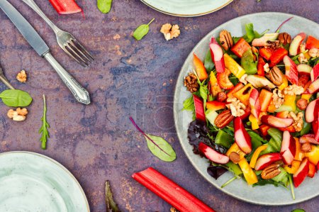Photo for Tasty salad of rhubarb, bell pepper,lettuce and nuts. Vegan salad. Top view - Royalty Free Image