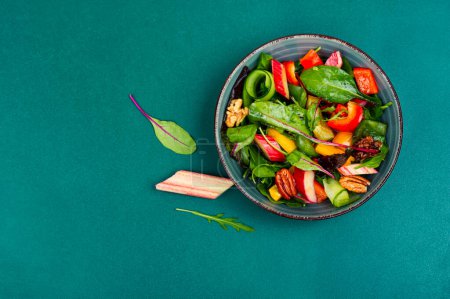 Vitamina deliciosa ensalada de ruibarbo, pimiento, hierbas y nueces en un tazón. Espacio para texto