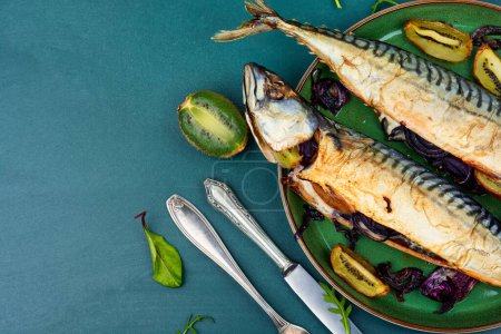 Photo for Whole tasty mackerel fish grilled with kiwi fruits. Copy space. - Royalty Free Image