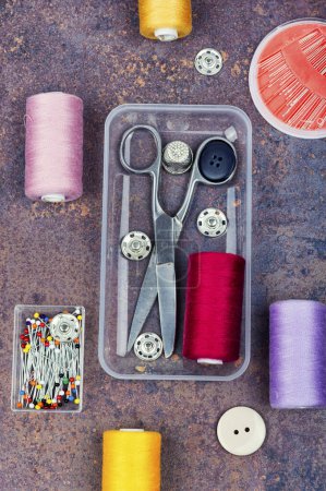 Téléchargez les photos : Kit de couture maison, ciseaux, aiguilles, boutons et fil coloré. Vue de dessus, plan plat - en image libre de droit