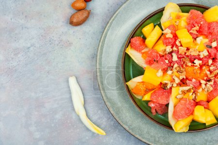 Téléchargez les photos : Freshly vitamin salad of grapefruit, mango and chicory. Copy space - en image libre de droit