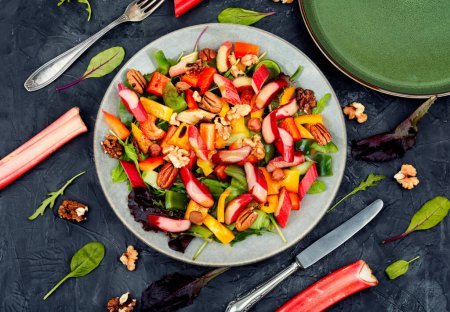 Téléchargez les photos : Délicieuse salade printanière de rhubarbe, poivron, herbes et mélanger les noix. Pose plate - en image libre de droit