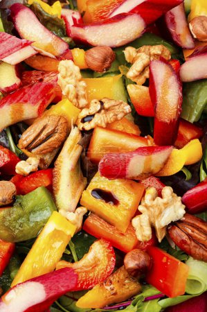 Téléchargez les photos : Salade légère fraîche de rhubarbe, poivron, salade de feuilles et noix. Gros plan, fond alimentaire - en image libre de droit