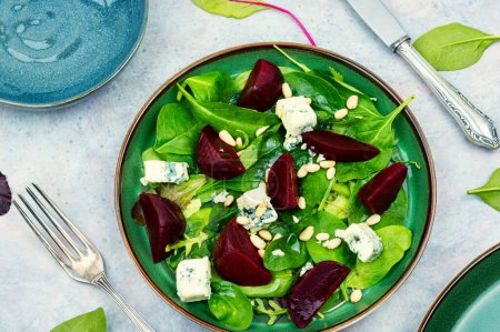 Téléchargez les photos : Salade savoureuse avec betteraves, fromage bleu, herbes et pignons de pin sur fond gris - en image libre de droit