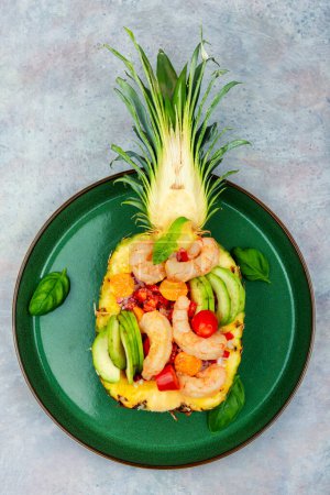 Téléchargez les photos : Half a pineapple with vegetables, rice and seafood.Shrimps salad in a pineapple. Asiatic cuisine - en image libre de droit