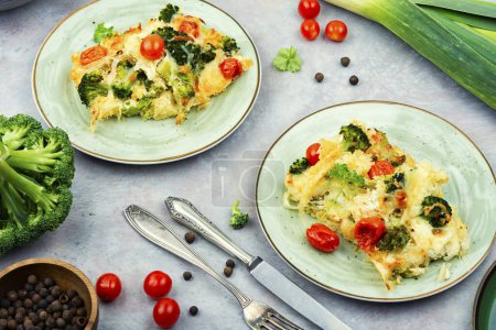Photo for Potato casserole or gratin with broccoli and tomatoes on a plate. French cuisine - Royalty Free Image