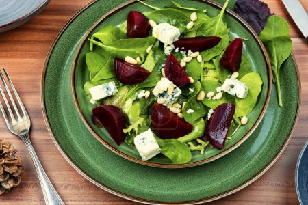 Téléchargez les photos : Salade de betteraves avec betteraves, fromage bleu, herbes et pignons dans l'assiette verte - en image libre de droit
