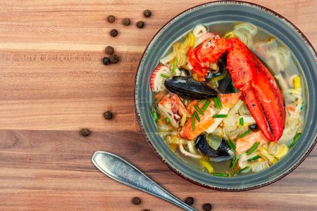 Téléchargez les photos : Fresh soup with lobster, mussels, shellfish and fish. Seafood soup. Copy space - en image libre de droit