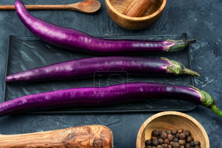 Photo for Raw small fresh eggplants or aubergine on the kitchen table. - Royalty Free Image