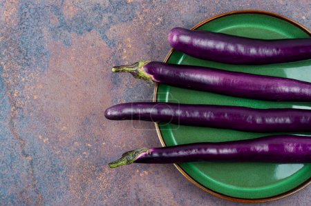 Photo for Raw small eggplants on the kitchen table. - Royalty Free Image