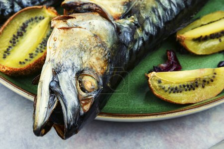 Photo for Whole tasty mackerel fish grilled with kiwi fruits. - Royalty Free Image