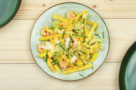 Photo for Delicious salad of mango, avocado and shrimp on wooden tables. Top view. - Royalty Free Image