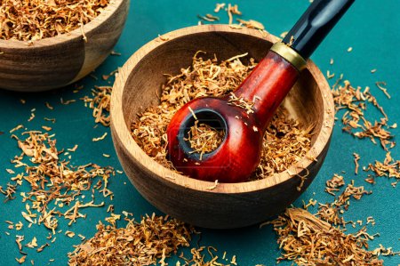 Photo for Fragrant smoking tobacco and a smoking tube or pipe on the table. - Royalty Free Image