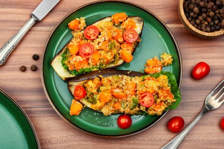 Téléchargez les photos : Aubergines farcies à la citrouille, tomates et quinoa dans une assiette. - en image libre de droit