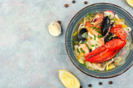 Photo for Seafood soup with lobster, mussels, shrimps and fish. Soup in ceramic bowl. Tom yum. Copy space - Royalty Free Image