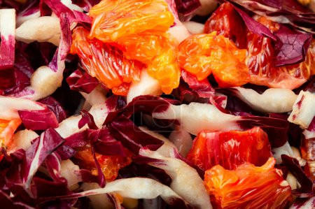 Foto de Ensalada de verduras con achicoria roja, pomelo y piñones en un plato. Fondo alimentario - Imagen libre de derechos