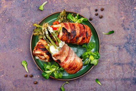 Photo for Meatloaf wrapped in bacon. Roasted green asparagus wrapped with meat . Top view - Royalty Free Image
