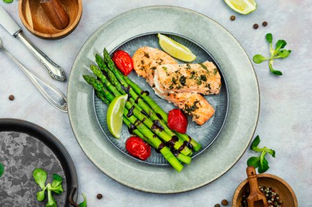 Photo for Roasted trout and boiled asparagus on the plate. Top view. - Royalty Free Image