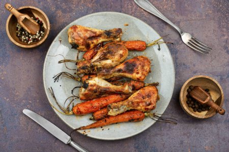 Photo for Grilled chicken drumsticks, roast chicken legs with carrots - Royalty Free Image