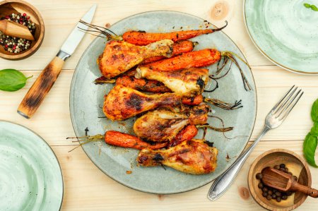 Téléchargez les photos : Jambes de poulet savoureuses cuites avec des carottes sur l'assiette. - en image libre de droit