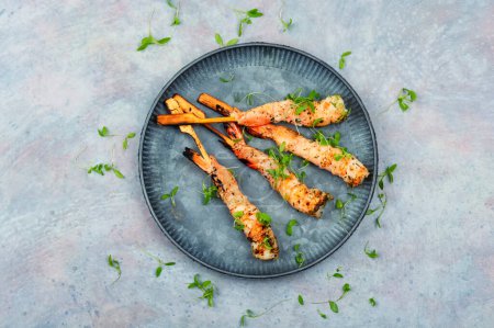 Photo for Classic shrimp or langoustines barbecue with herbs grilled on wooden sticks. Top view - Royalty Free Image