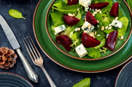 Téléchargez les photos : Beetroot salad with beets, blue cheese, herbs and pine nuts on the green plate - en image libre de droit