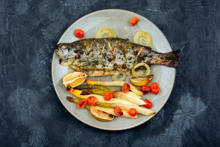 Photo for Delicious whole river trout baked with white asparagus and tomatoes. - Royalty Free Image