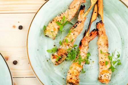 Photo for Tasty shrimp barbecue with herbs fried on sticks. Seafood. Flat lay - Royalty Free Image