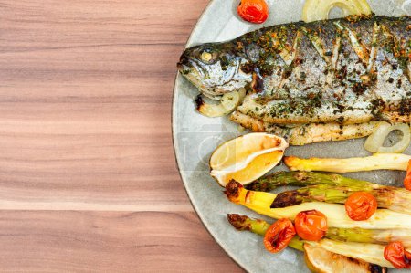 Photo for Grilled trout with asparagus. Baked salmon fish on wooden table. Copy space. - Royalty Free Image