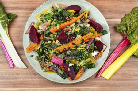 Téléchargez les photos : Salade chaude de blettes cuites, betteraves et carottes aux graines de citrouille. Une alimentation saine - en image libre de droit