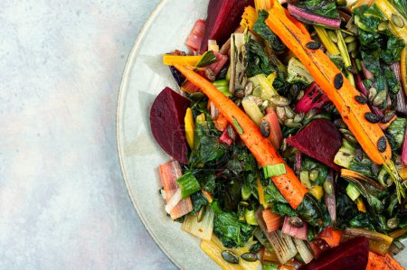 Téléchargez les photos : Salade de blettes confites, betteraves et carottes aux graines de citrouille. Concept végétarien d'aliments sains - en image libre de droit
