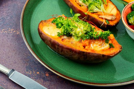 Photo for Baked sweet potato stuffed with mushrooms, broccoli and peppers. Vegan food - Royalty Free Image