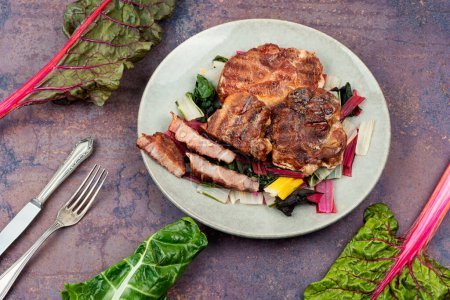 Téléchargez les photos : Steak de viande rôtie juteuse sur un oreiller de légumes. - en image libre de droit
