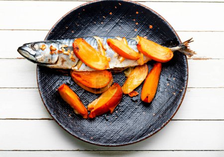 Photo for Fish cooked in persimmon fruit marinade. Whole baked fish, mackerel. - Royalty Free Image